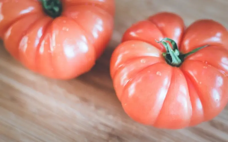 pink oxheart tomatoes on cutting board